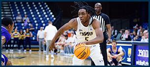 Number 3 men's basketball player dribbling ball down the court