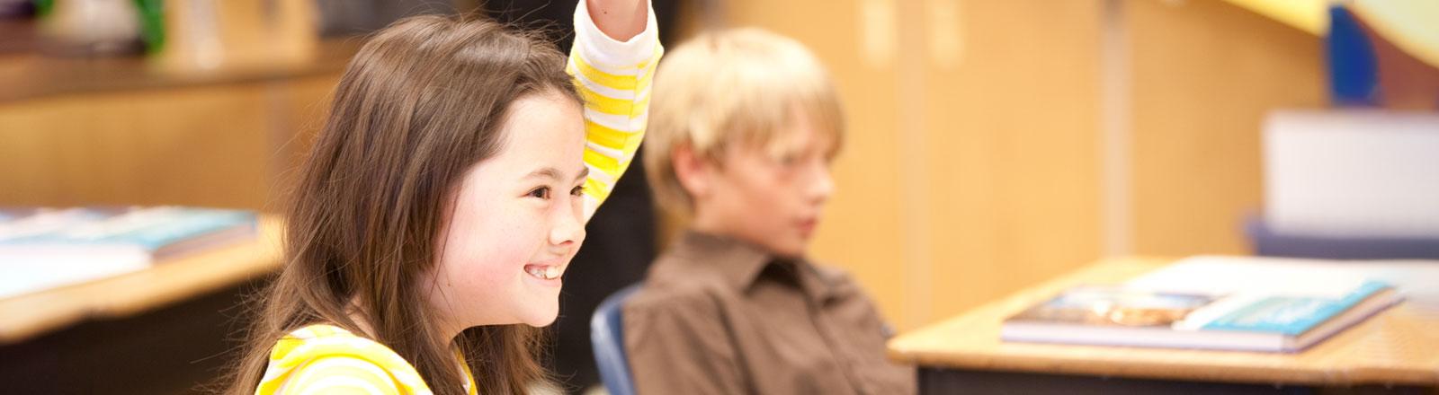 Child raising hand in classroom